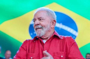 Lula com bandeira do Brasil ao fundo.